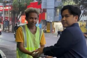 Duta Kampus ITN Malang memberikan nasi kotak kepada tukang parkir
