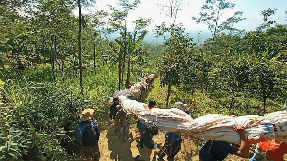 Bendera merah putih selebar 1.800 meter persegi (30 M x 60 M) dan berat mencapai 400 kg (4 kuintal) secara bergotong royong diangkat ke puncak Gunung Sangkuk oleh Himakpa dan warga. (Foto: Istimewa)