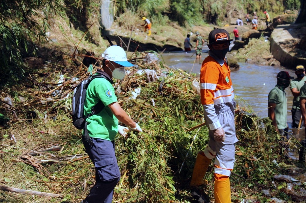 Kaprodi Teknik Lingkungan ITN Malang Sudiro, ST,MT (berkaos hijau) ikut membersihkan sampah bersama warga masyarakat di Sungai Metro. (Foto: Ari/humas)