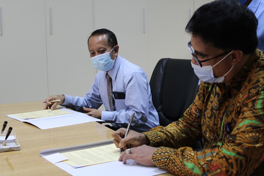 Rektor Universitas Katolik Widya Karya Malang Dr. Klemens Mere, SE., MPd., MM., MH., MAP (baju batik) membubuhkan tanda tangan di draf MoU. (Foto: Yanuar/humas)