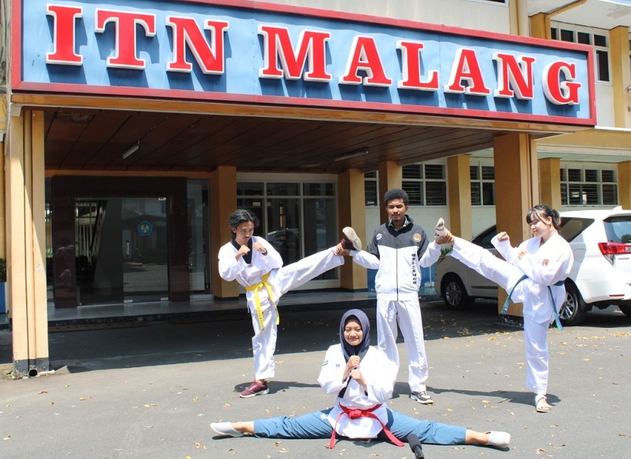 Tim UKM Taekwondo ITN Malang. Berdiri (ki-ka): Ahmada Itmamunnafi', Rocky Abraham Yunior Tuka, Reva Nabila Putri, dan Bernika Natasya Ifada (duduk) berpose di depan gedung Rektorat ITN Malang. (Foto: Mita/humas)