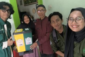 Mahasiswa Teknik Lingkungan ITN Malang saat menyerahkan bak sampah kepada warga Kelurahan Candirenggo